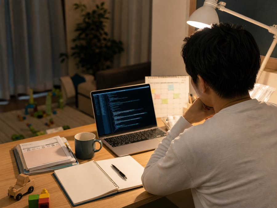 仕事後の夜、自宅でプログラミング学習を進める様子